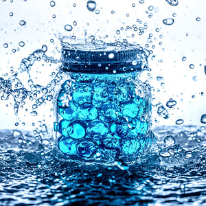 Blue gel beads in a jar in a splash of water