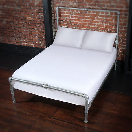 Bed featuring fluidproof white fitted sheet and matching pillowcases.which are now available.
